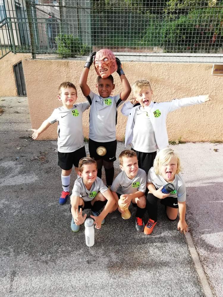 Des jeunes footballeurs posent avec une ambiance joyeuse et un masque d'horreur.