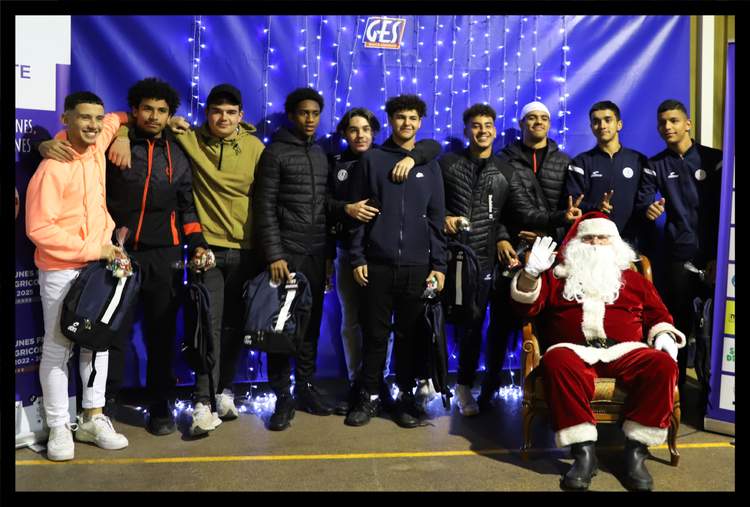 Un groupe de jeunes footballeurs posent avec le Père Noël lors d'un événement festif.